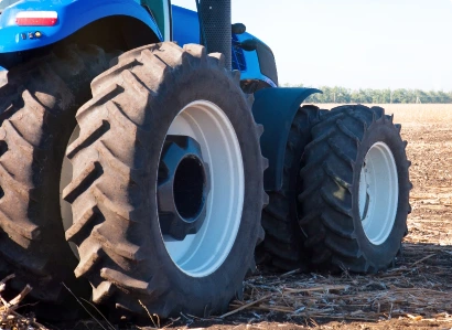 En traktor och dess däck i fokus på öppet landskap